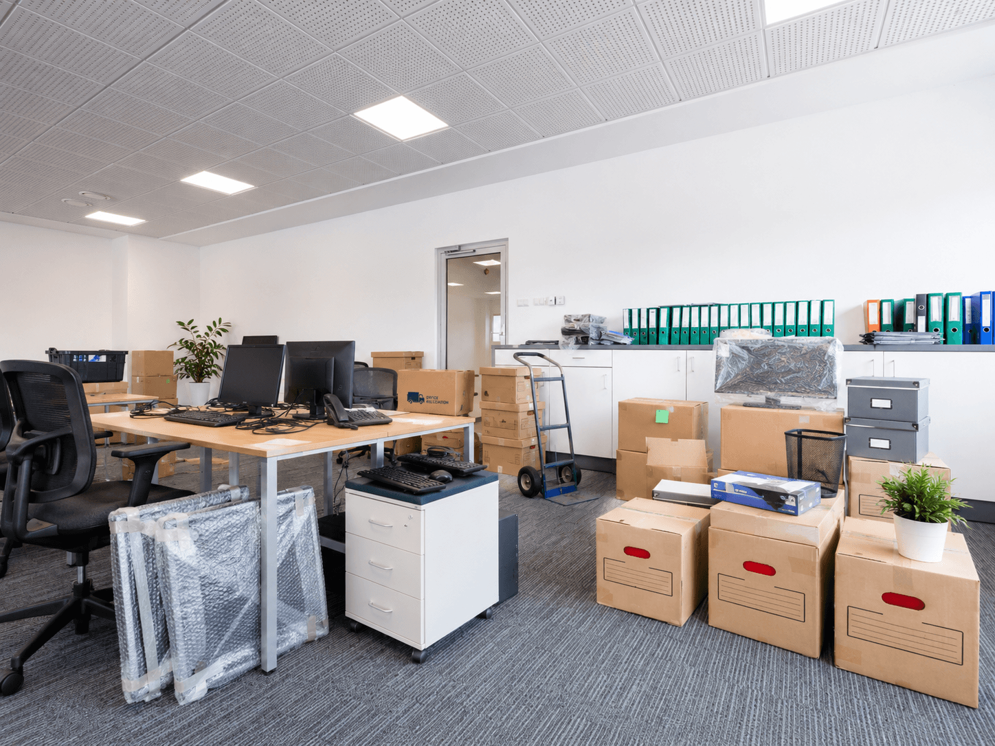 Büro mit Umzugskartons, Schreibtischen und Technik – vorbereitet für den Firmenumzug
