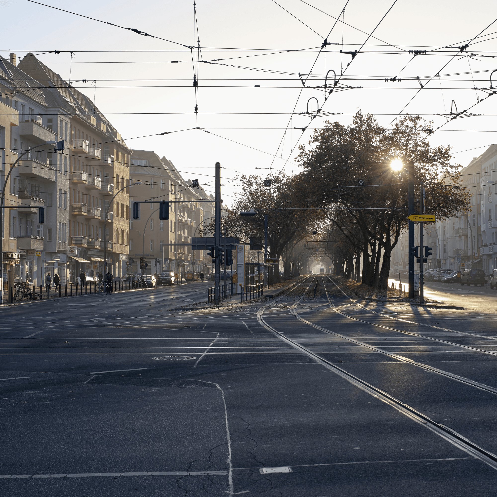 Berliner Straße mit Altbauten, Straßenbahn und Bäumen