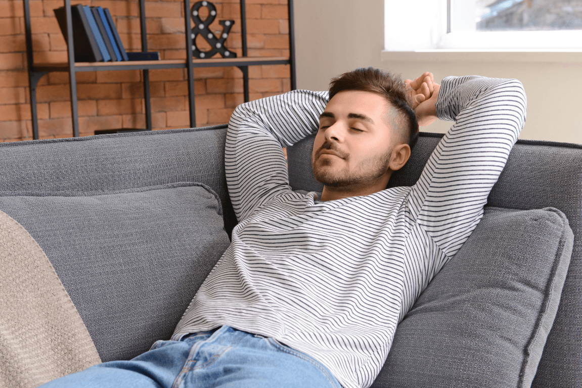 Mann entspannt auf dem Sofa nach dem Umzug