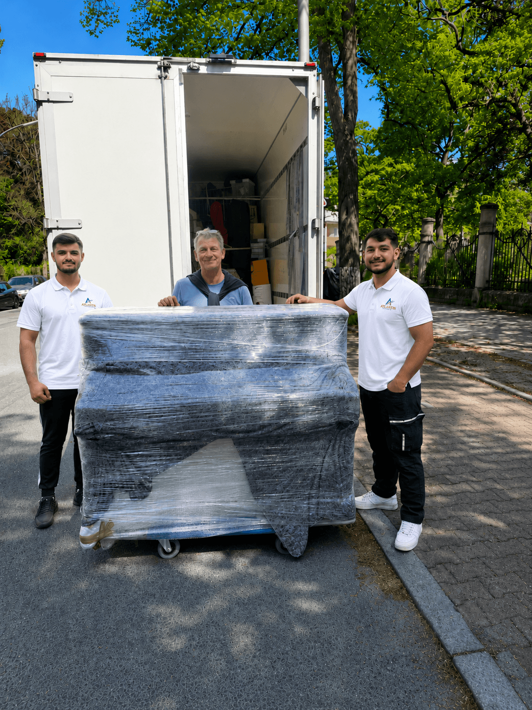 Atlantis Umzüge Team mit eingepacktem Klavier vor dem Umzugslaster